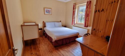 a small bedroom with a bed and a window at Moulamill Cottage Bed and Breakfast Glenlough P75RY86 in Ahakista