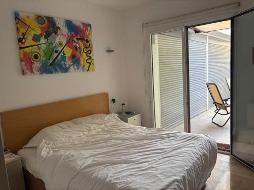 a bedroom with a bed and a painting on the wall at Spacious open plan ground floor apartment in Port de Pollensa
