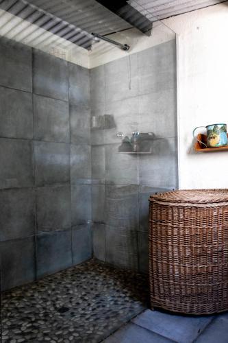 a bathroom with a shower with a sink and a basket at Douglas Drift Cottages in Underberg