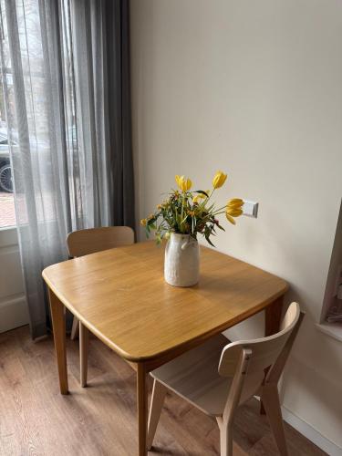 a wooden table with a vase of flowers on it at studio at the Rijksmuseum in Amsterdam