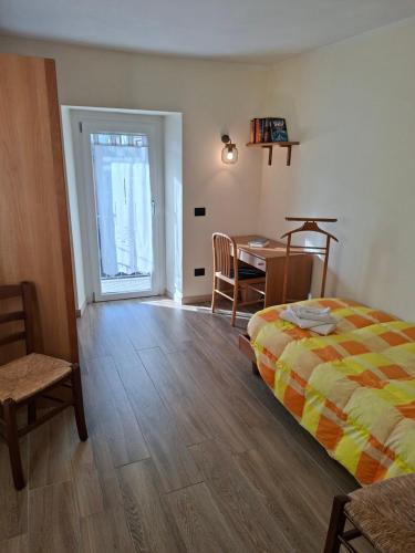 a bedroom with a bed and a table and a dining room at La corte in Vezzo