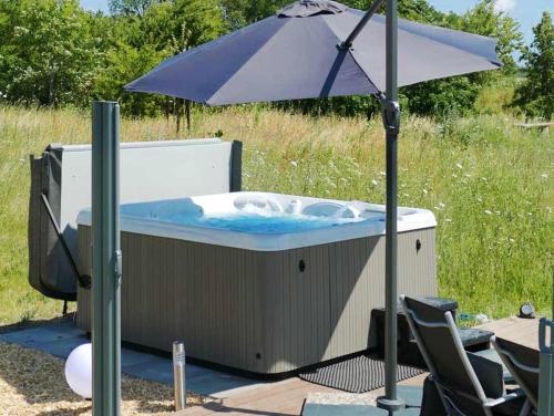 a hot tub with an umbrella and a table and chairs at Villa Silbermöwe in Trent