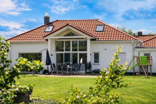 a house with a conservatory with a table and chairs at Villa Silbermöwe in Trent