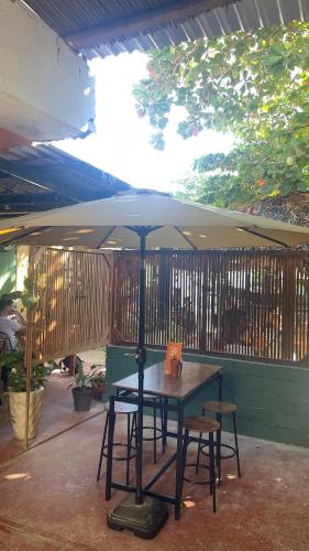 a table and two chairs under an umbrella at Olivo Hostel, Punta Zicatela in Puerto Escondido