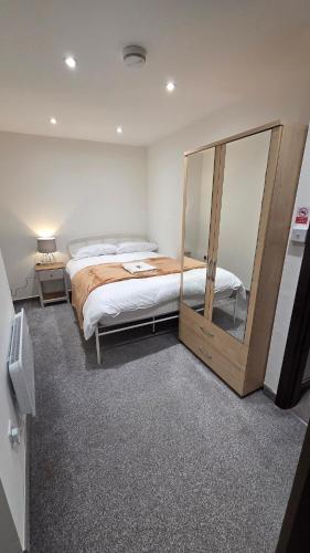 a bedroom with a bed and a large mirror at Modern 2-Bed High Spec Flat Apartment in Town Centre in Blackburn
