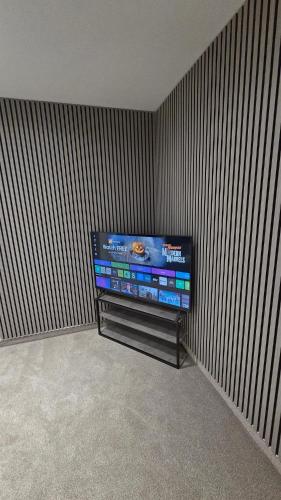 a flat screen tv in a corner of a room at Modern 2-Bed High Spec Flat Apartment in Town Centre in Blackburn