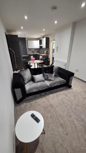 a living room with a couch and a table at Modern 2-Bed High Spec Flat Apartment in Town Centre in Blackburn