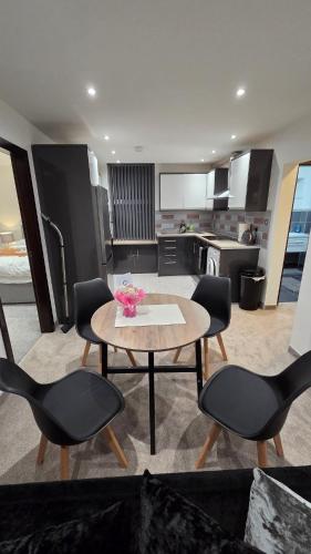 a living room with a table and chairs and a kitchen at Modern 2-Bed High Spec Flat Apartment in Town Centre in Blackburn