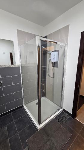 a shower with a glass door in a bathroom at Modern 2-Bed High Spec Flat Apartment in Town Centre in Blackburn