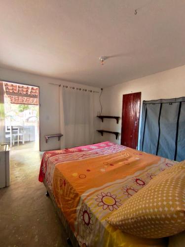 a bedroom with a bed with an orange blanket at Chalé em Tatajuba in Tatajuba
