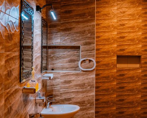 a bathroom with a sink and a mirror at Royal Crown Hotel - Kigali in Kigali