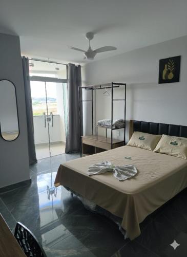 a bedroom with a bed and a large window at Hotel Porto Real in Pôrto Real