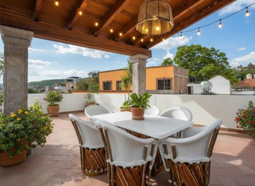 a patio with a white table and chairs at Casa del Palmar, Elegant 3BR Home with Rooftop in Centro San Miguel in San Miguel de Allende