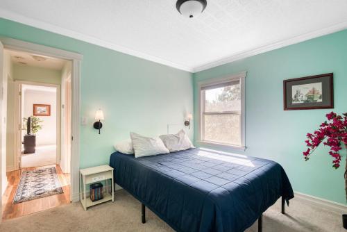 a blue bedroom with a bed and a window at La Maison - Elegant 2BR Escape - Free Breakfast! in Albany