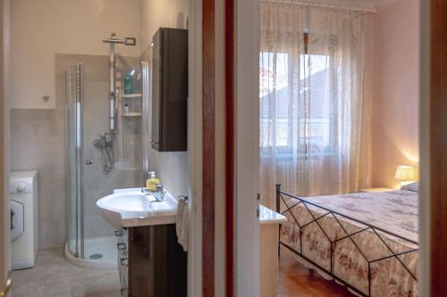 a bathroom with a sink and a shower and a bed at Casa Niky in Verbania