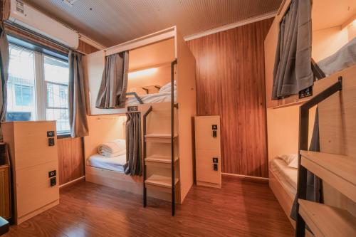 a dorm room with bunk beds and a tv at POSHPACKER - Chengdu Mix Hostel - Cicada Zen Yard in Chengdu