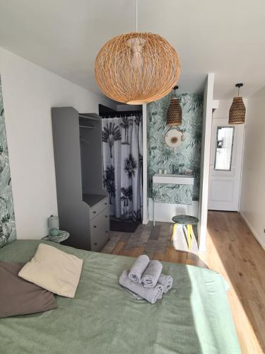 a bedroom with a bed with two towels on it at Le Petit Chêne in Orgnac-lʼAven