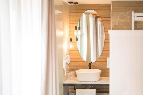 a bathroom with a sink and a mirror at Hostal riMboMbin in Burgos