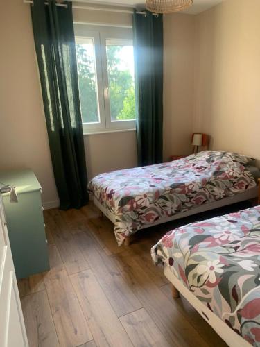 a bedroom with two beds and a window at Gîte le Haut de la Marche in La Lanterne-et-les-Armonts