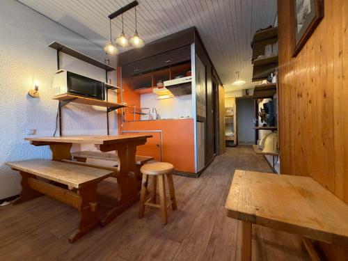 une cuisine avec une table en bois et un micro-ondes dans l'établissement Studio centre Val d'Isere, à Val dʼIsère