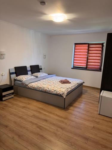a bedroom with a bed and a wooden floor at Cazare & Restaurant Dalia in Socodor
