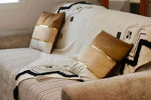 a bed with pillows on top of it at La Maison des Cocotiers in Petite Île