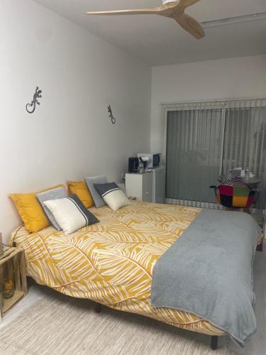 a bedroom with a large bed with yellow pillows at Chez Fabrice in Lunel