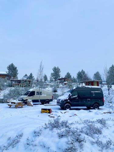two vehicles parked in a parking lot covered in snow at Offroadcamp Dalarna - Adventure Camping & Cabins in Sörsjön