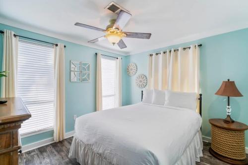a bedroom with a white bed and a ceiling fan at Sunkissed Oasis in Navarre