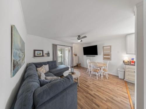 a living room with a blue couch and a table at Sea The Good condo in Carolina Beach