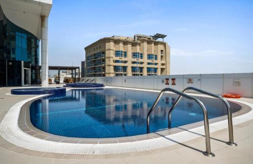 a large swimming pool in front of a building at Stylish 1BR close to Metro and Dubai Marina in Dubai