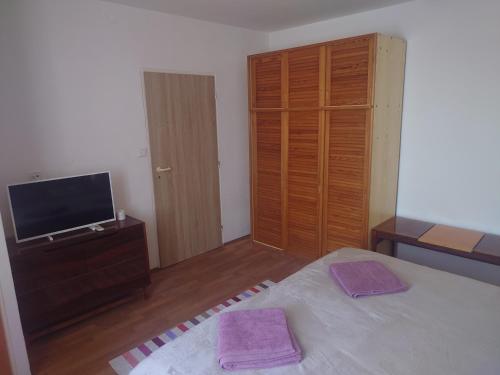 a bedroom with a bed and a dresser and a television at Zukalka 2KK - 2 in Ostrava