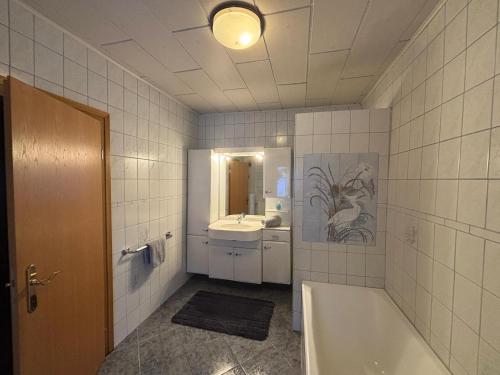 a bathroom with a bath tub and a sink at Ferien- & Monteurswohnung Krüger Werra Suhl Tal in Raßdorf