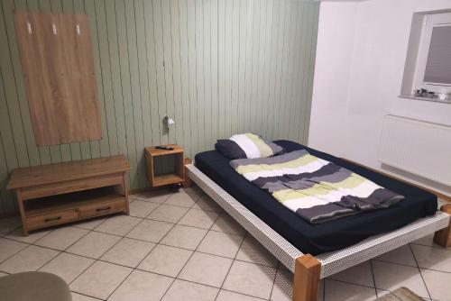 a bedroom with a bed and a night stand at Private room with own bathroom in Harsum