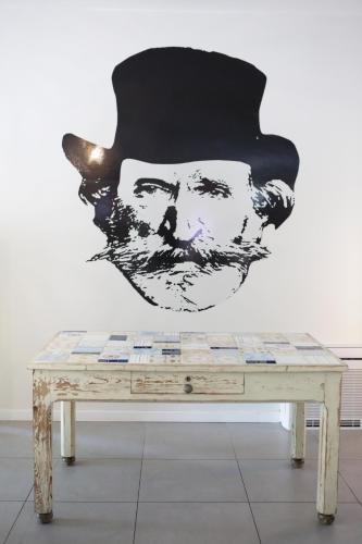 a painting of a man with a hat on a wall at Ostello Meet Gardalake Hostel in Peschiera del Garda