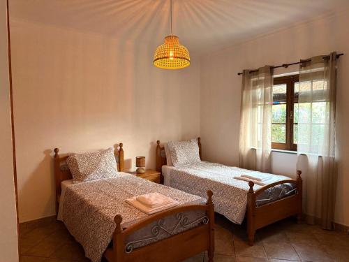 a bedroom with two beds and a chandelier at Casa do Sol in Safara