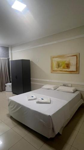 a bedroom with a large white bed with towels on it at Hotel Eduardus in Palmas