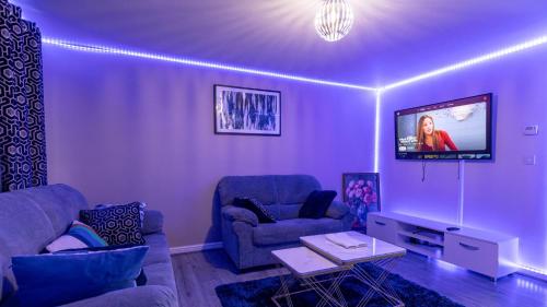 a living room with two couches and a flat screen tv at Entire 3 bedroom luxurious house, Wigan , Manchester in Wigan