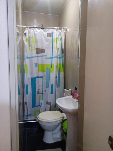 a bathroom with a toilet and a shower curtain at Arequipa- LaPampilla in La Pampilla
