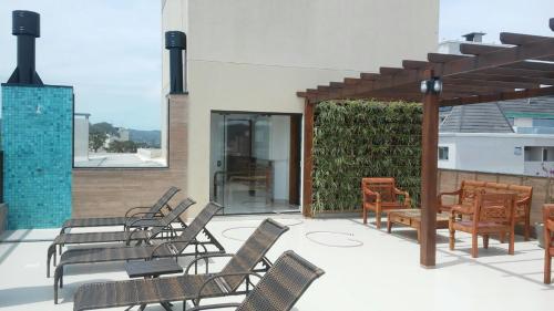 a group of chairs and tables on a patio at Fragata Apart Hotel in Florianópolis