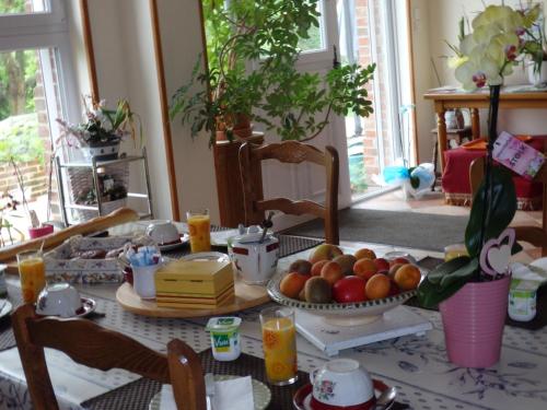 ein Tisch mit einem Teller Obst darauf in der Unterkunft Les Trois Pommiers in Sommery