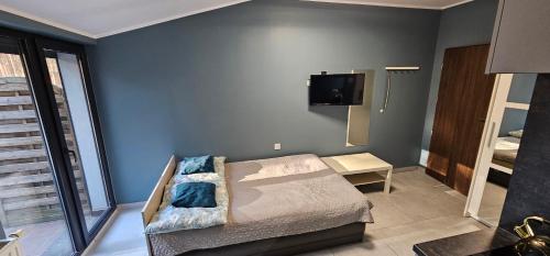 a bedroom with a bed and a tv on the wall at Apartament Słoneczna in Radzyń