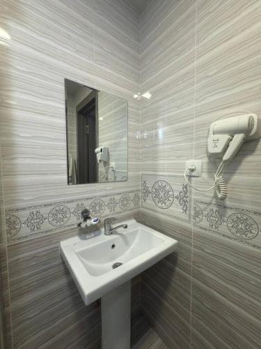 a bathroom with a sink and a mirror at Almaz PLAZA in Tashkent