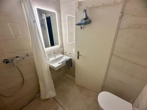 a bathroom with a toilet and a sink and a shower at Ferienwohnung C12 in Orselina