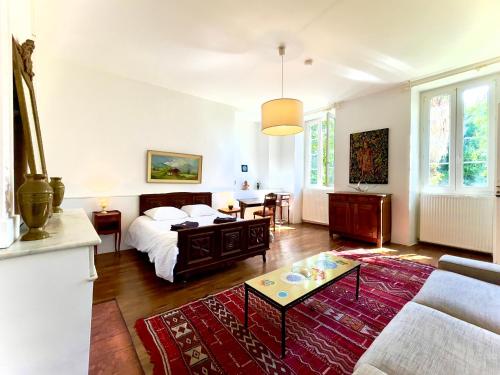 a living room with a bed and a couch at La Demeure des Fleurs in Caillavet