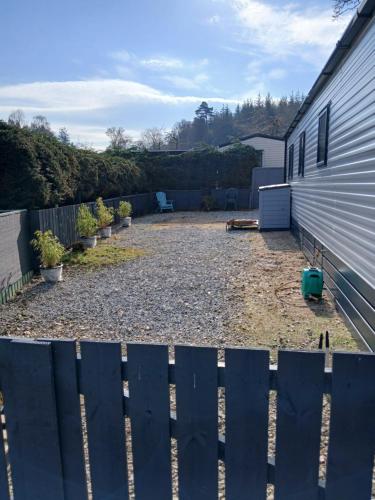 a backyard with a fence next to a house at The Robin's Nest in Fochabers
