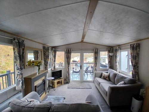 a living room with a couch and a tv at The Robin's Nest in Fochabers