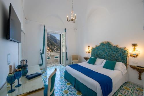a bedroom with a bed with a blue and white bedspread at Hotel Reginella in Positano