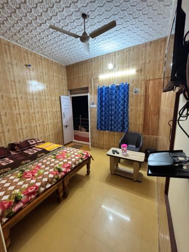 a bedroom with a bed and a table and a ceiling at Happy Hills in Yelagiri