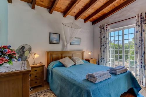 a bedroom with a blue bed and a window at Quinta Velha by GT House in Portimão